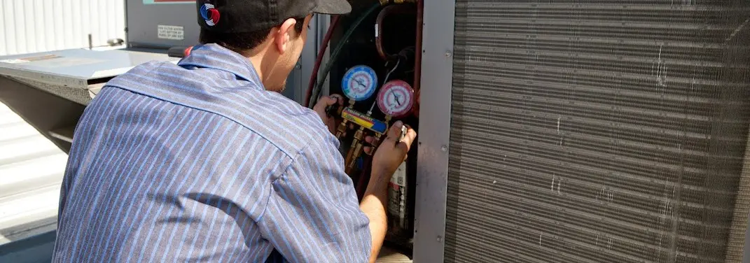HVAC technician servicing a condenser unit in Esopus